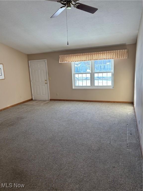 empty room with ceiling fan and carpet floors