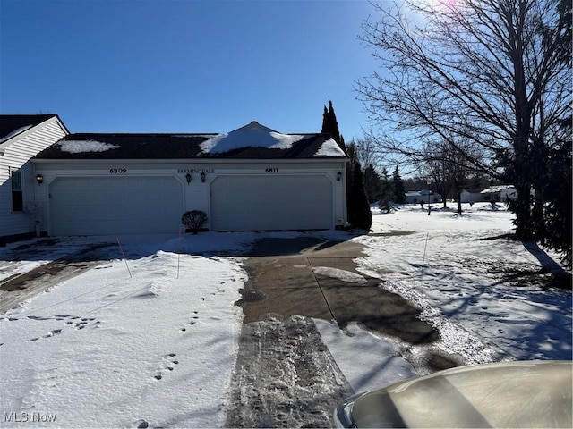 view of snowy exterior featuring a garage