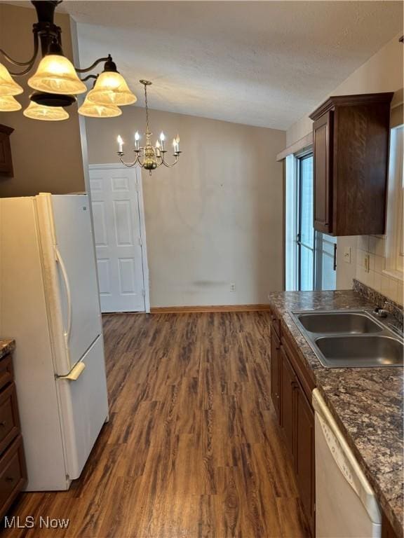 kitchen with pendant lighting, sink, white appliances, dark hardwood / wood-style floors, and decorative backsplash