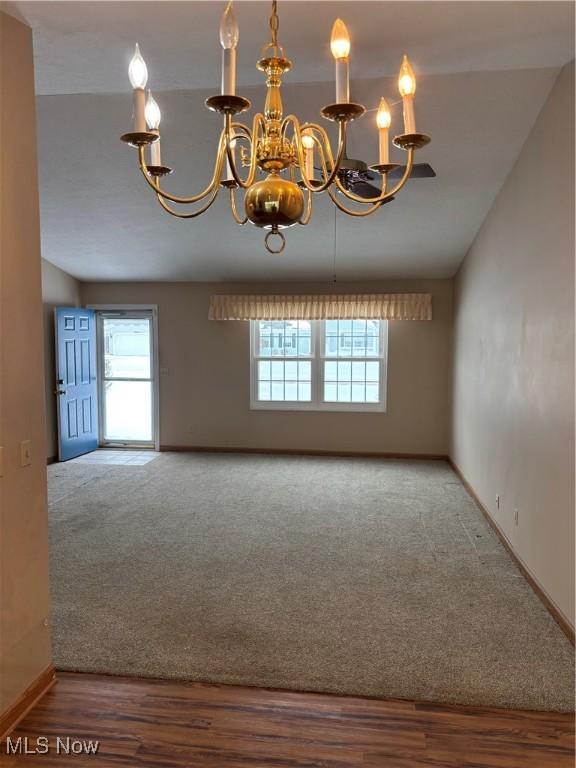 unfurnished room featuring carpet flooring and a chandelier