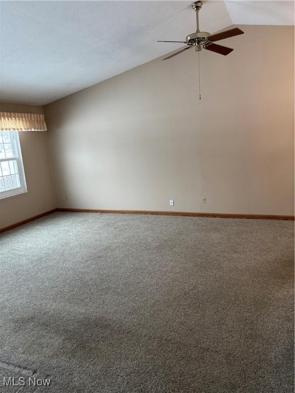 unfurnished room featuring lofted ceiling, ceiling fan, and carpet