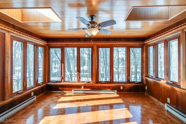 unfurnished sunroom featuring wood ceiling, a baseboard radiator, and a wealth of natural light