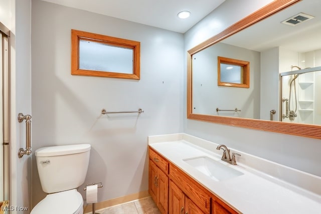 bathroom featuring vanity, walk in shower, tile patterned floors, and toilet