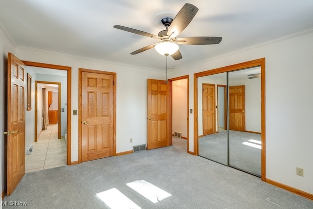 unfurnished bedroom featuring light colored carpet, ornamental molding, and ceiling fan