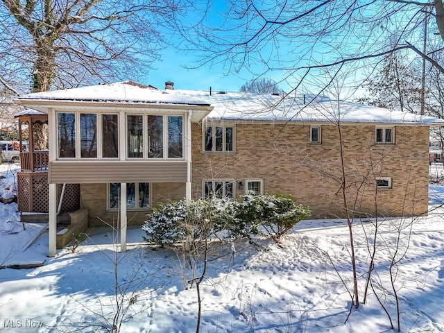 view of snow covered back of property