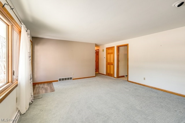 carpeted empty room with baseboard heating