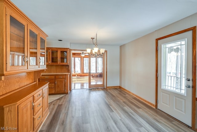 unfurnished dining area featuring a chandelier and light hardwood / wood-style floors