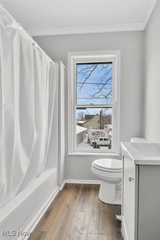 full bathroom with shower / bath combination with curtain, hardwood / wood-style flooring, vanity, ornamental molding, and toilet