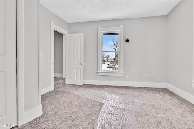 carpeted spare room featuring a textured ceiling