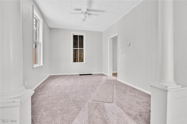 spare room with decorative columns, carpet, and ceiling fan