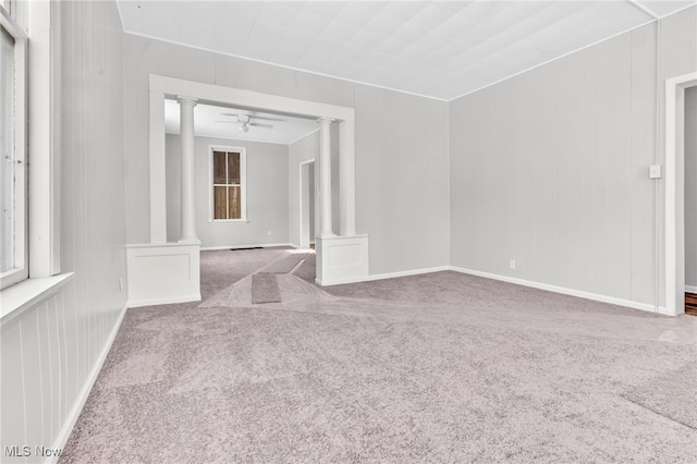 carpeted spare room featuring ceiling fan and decorative columns