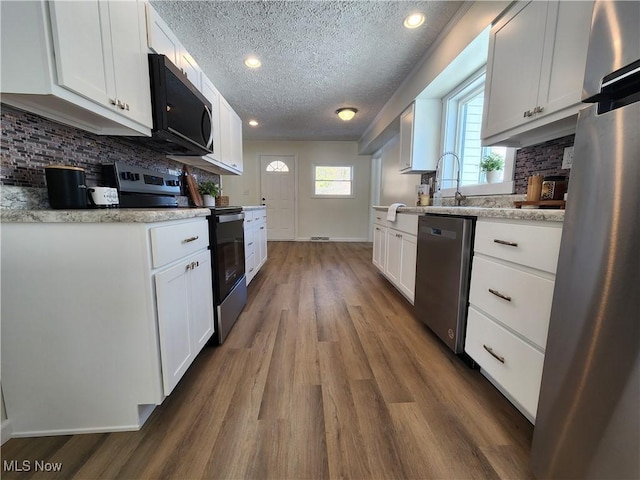 kitchen with white cabinetry, appliances with stainless steel finishes, and a textured ceiling