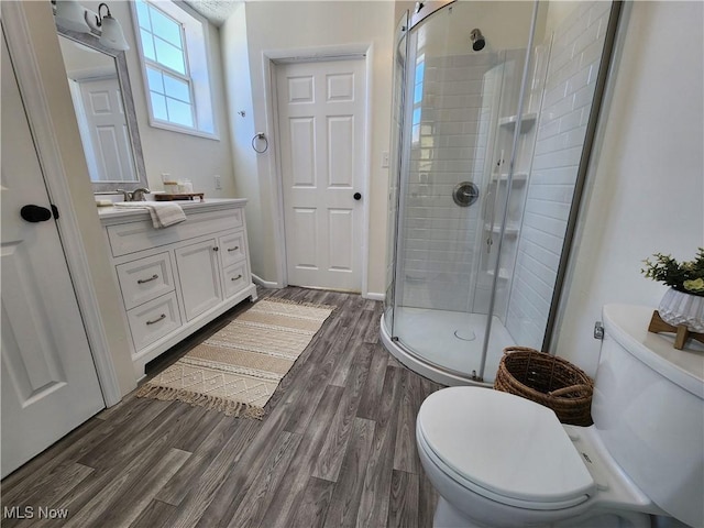 bathroom featuring vanity, hardwood / wood-style floors, toilet, and walk in shower