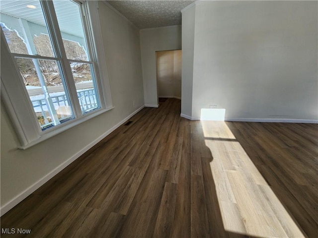 empty room with dark hardwood / wood-style floors and a textured ceiling