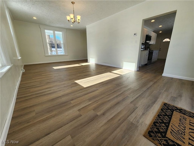 interior space with dark hardwood / wood-style flooring, a textured ceiling, and a notable chandelier