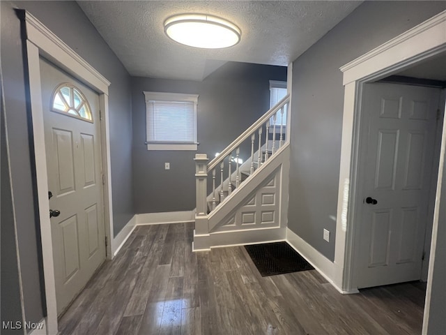 foyer featuring dark hardwood / wood-style flooring and a textured ceiling