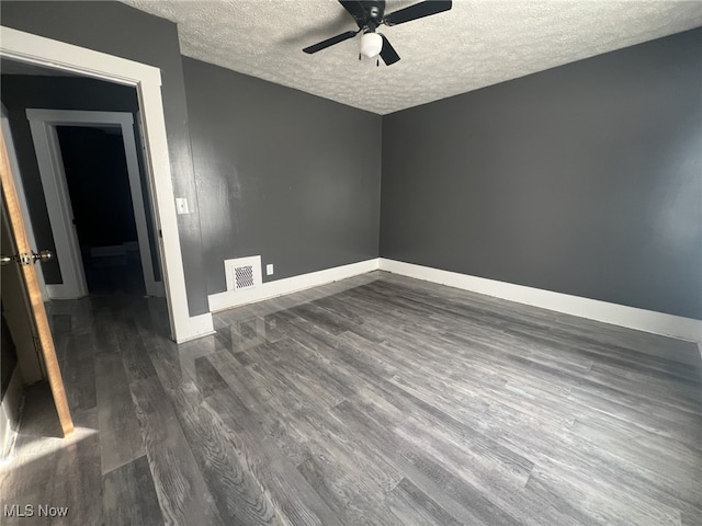 unfurnished room with ceiling fan, dark wood-type flooring, and a textured ceiling