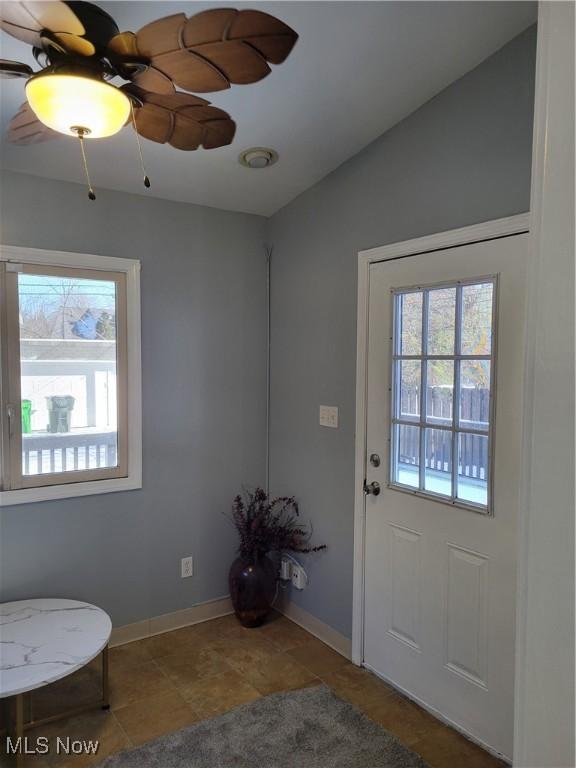 doorway with tile patterned flooring, vaulted ceiling, and plenty of natural light