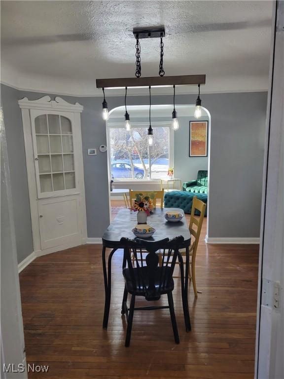 dining area with dark hardwood / wood-style flooring and a textured ceiling