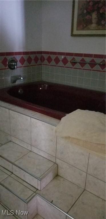 bathroom with tile patterned flooring and a bathtub