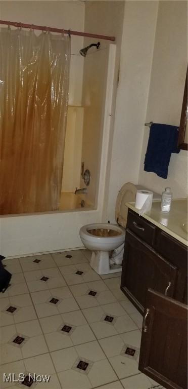 bathroom with tile patterned flooring, shower / bath combination with curtain, and toilet