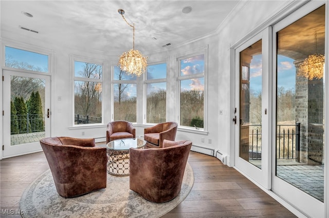 sunroom featuring a baseboard radiator and a chandelier