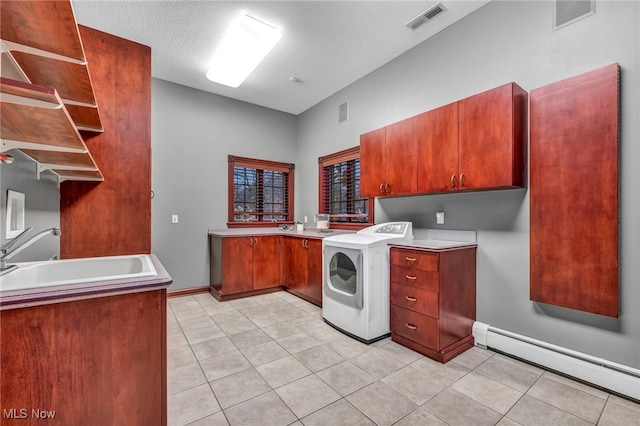 laundry area featuring a baseboard radiator, washer / dryer, sink, cabinets, and light tile patterned floors