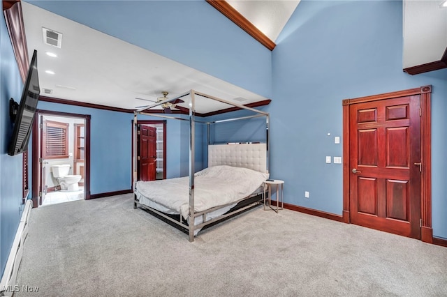 unfurnished bedroom with ornamental molding, carpet, a baseboard heating unit, ceiling fan, and ensuite bath