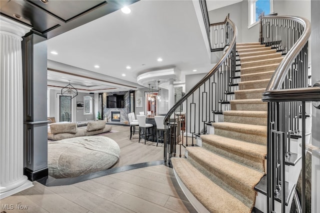 staircase featuring hardwood / wood-style floors and decorative columns