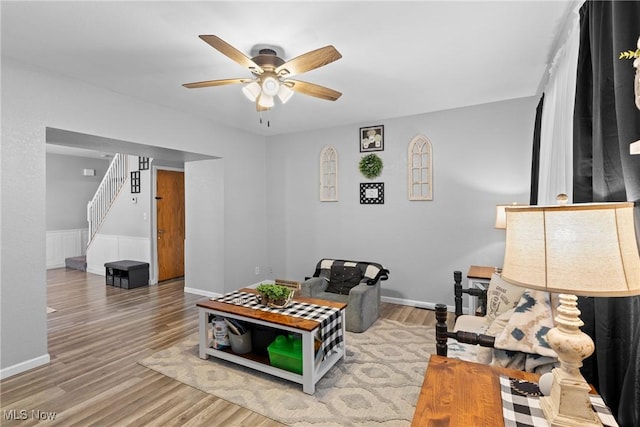 living room featuring wood-type flooring and ceiling fan