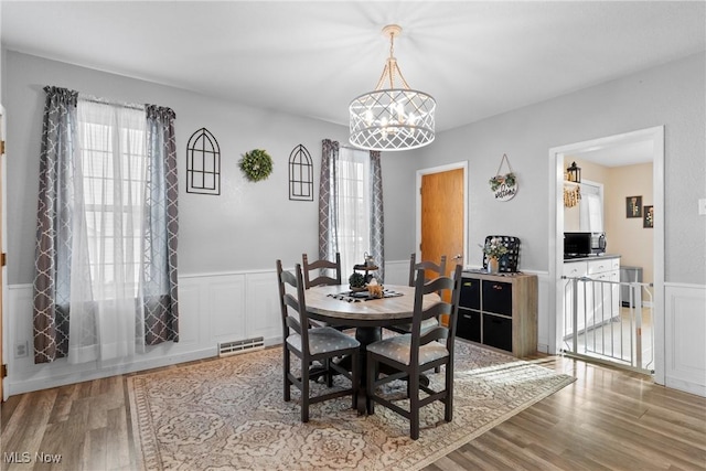 dining area with a notable chandelier and light hardwood / wood-style flooring