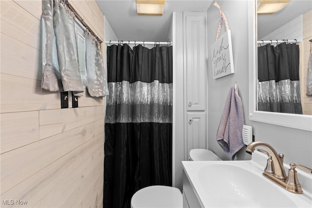 bathroom featuring walk in shower, toilet, and sink