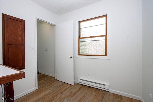 spare room with a baseboard radiator and light hardwood / wood-style floors