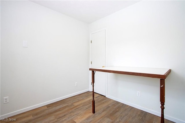 interior space with baseboards and wood finished floors