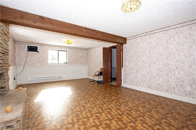 basement featuring a textured ceiling, baseboards, baseboard heating, a wall mounted AC, and wallpapered walls