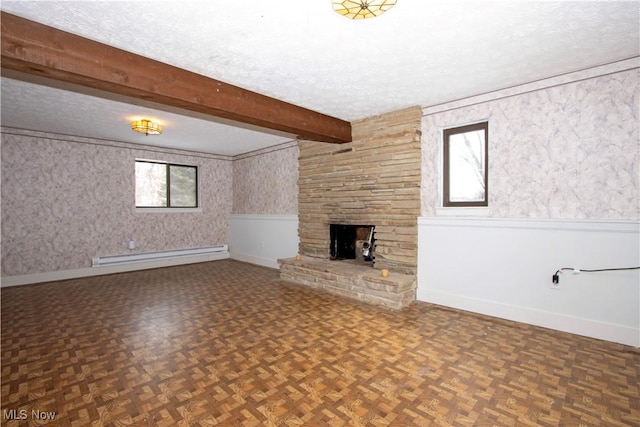 unfurnished living room featuring beam ceiling, a textured ceiling, baseboard heating, and a stone fireplace