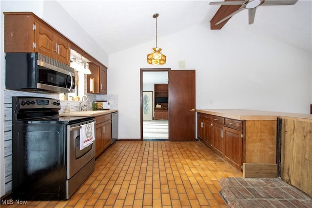 kitchen with vaulted ceiling with beams, stainless steel appliances, a sink, light countertops, and pendant lighting