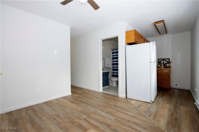 interior space with ceiling fan, light hardwood / wood-style floors, and white fridge