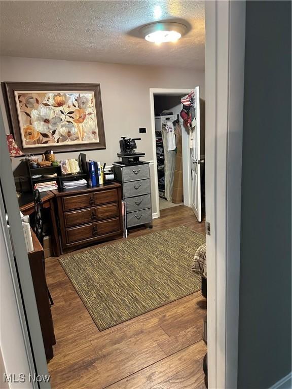 office featuring a textured ceiling and light hardwood / wood-style flooring