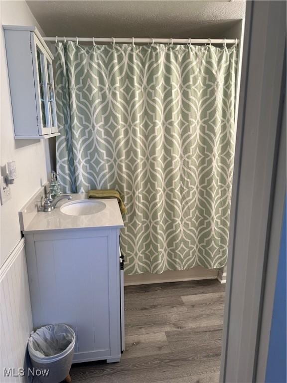 bathroom featuring wood-type flooring, vanity, and a textured ceiling