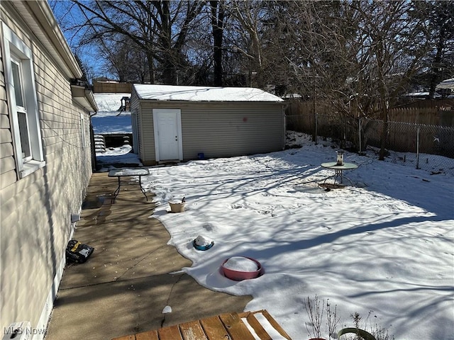 yard covered in snow featuring a shed