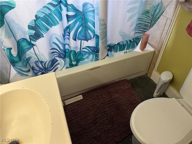 bathroom with shower / bath combination with curtain and toilet