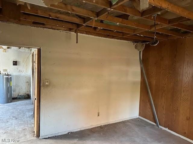 miscellaneous room featuring water heater and concrete flooring