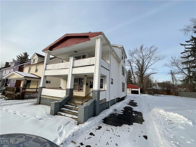 view of snowy exterior featuring a garage and a balcony