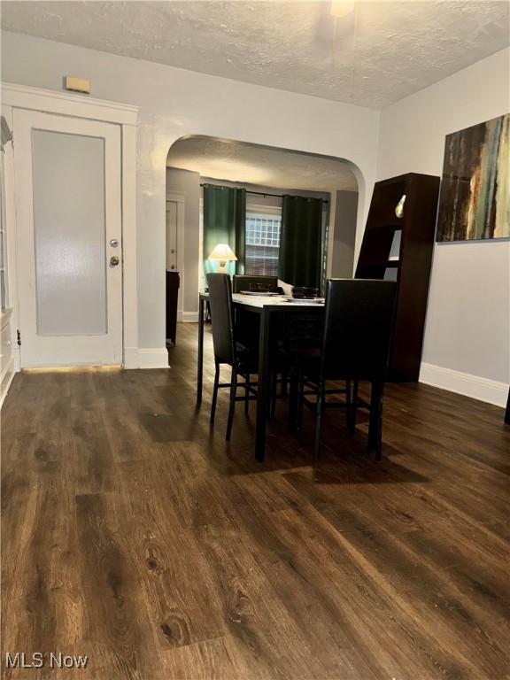 dining area featuring dark wood-type flooring and a textured ceiling