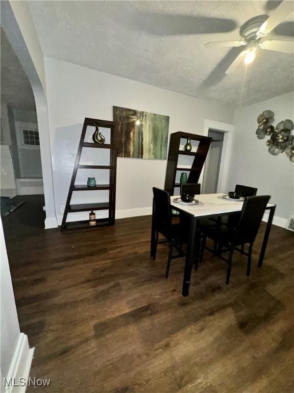 dining space with ceiling fan, dark hardwood / wood-style floors, and a textured ceiling