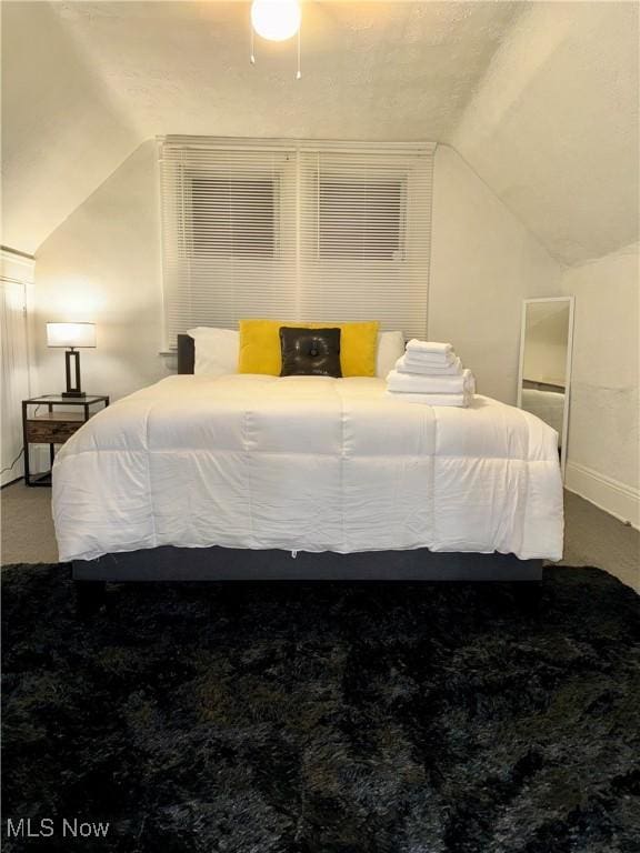 bedroom featuring lofted ceiling and carpet flooring