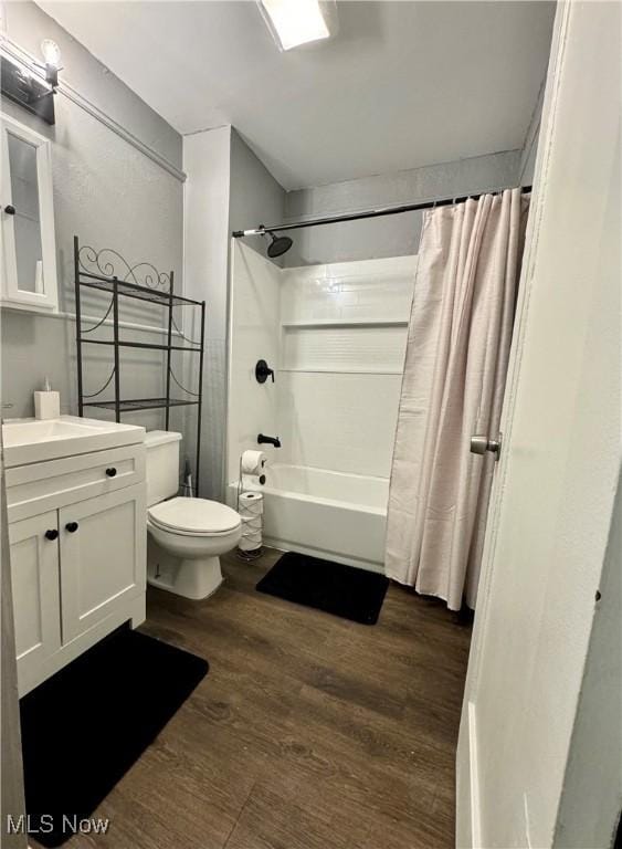 full bathroom with hardwood / wood-style flooring, vanity, shower / tub combo with curtain, and toilet