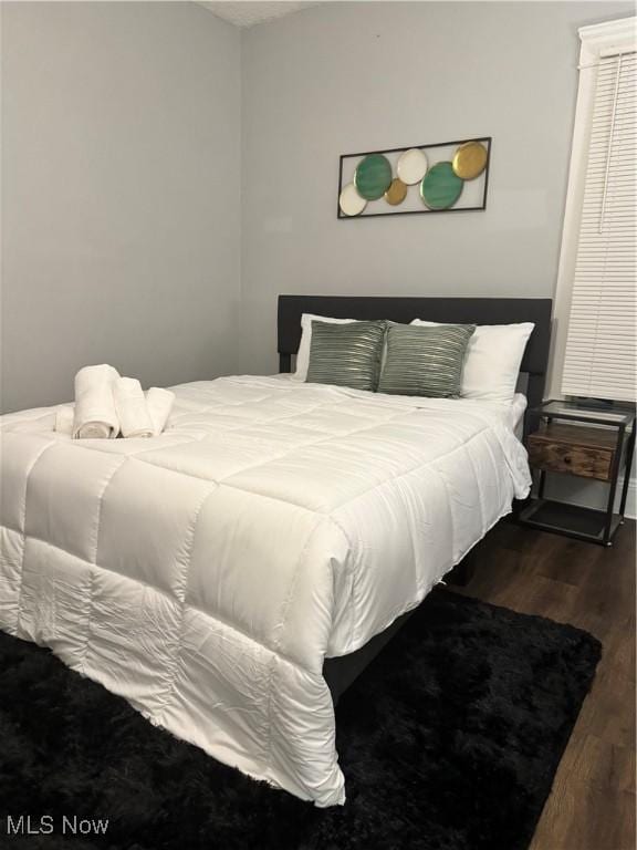 bedroom with dark hardwood / wood-style flooring