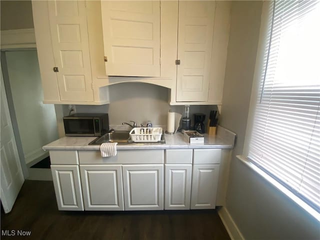 kitchen with white cabinetry, sink, and dark hardwood / wood-style floors